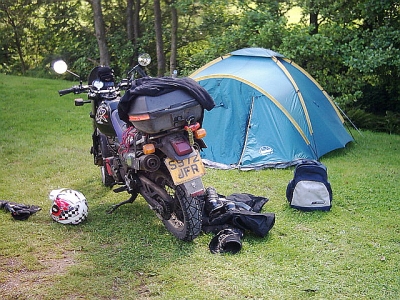 a motorbike surrounded by camping equipment and clothes